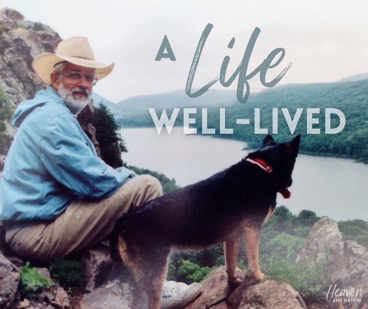 My dad and his dog, overlooking a lake and hills
