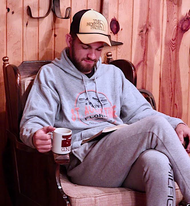 young man sitting with coffee reading his Bible