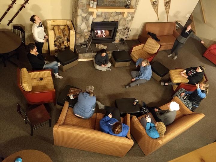 a group of women in a cozy lodge worshiping together