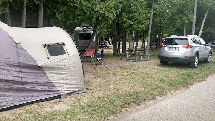 tent and vehicle at a small campsite in a public campground