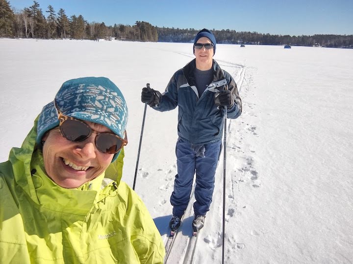 two people cross country skiing on a frozen lake