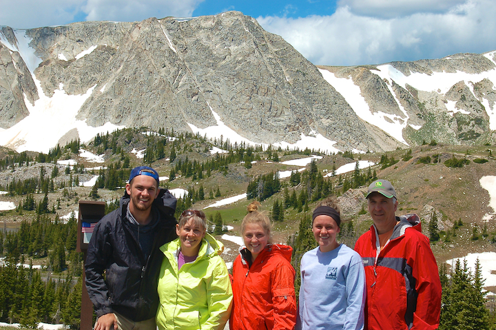 five people standing in front of the mountains