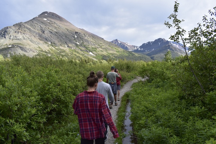 four hikers on mountain trail