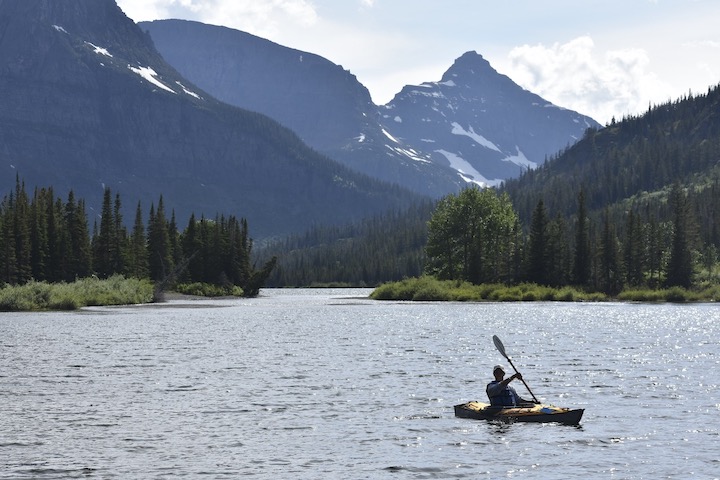 Kayaker on Two Medicine Lake, mountains in the background
