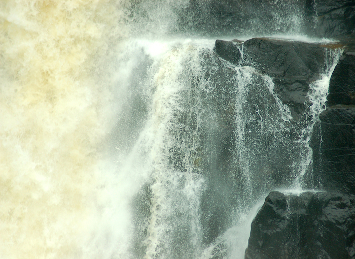 waterfall gushing over basalt rock