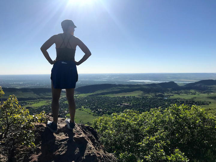 woman standing on a rock overlooking a vast area