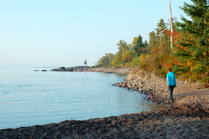 woman walks along a pebble beach