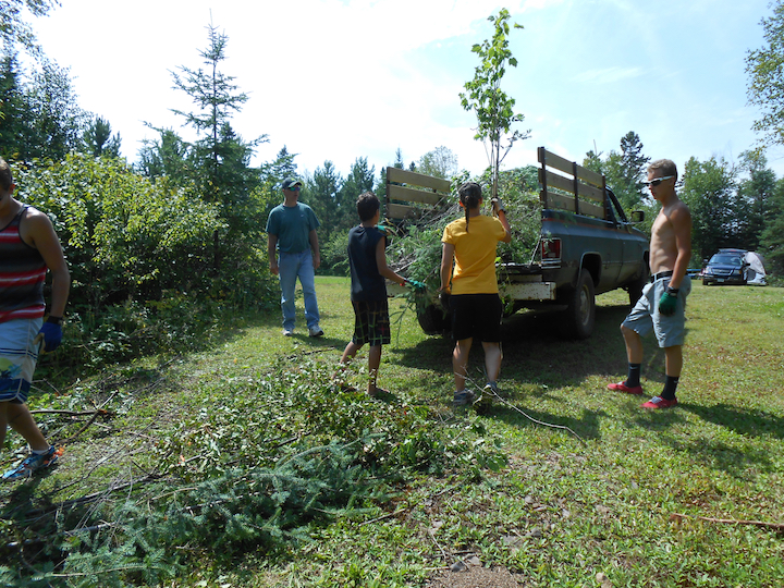 teens and adults hauling brush into a pickup truck