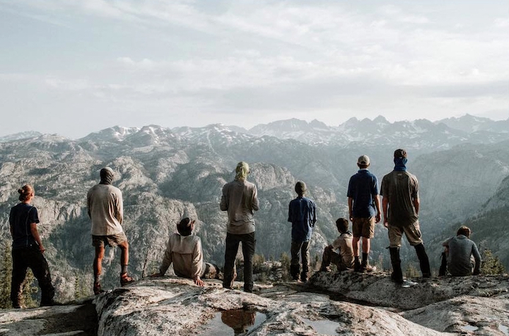 a group of teen boys on a mountain summit, overlooking miles of mountains