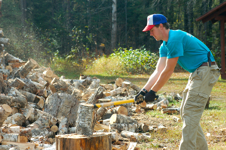 man chops wood with an ax