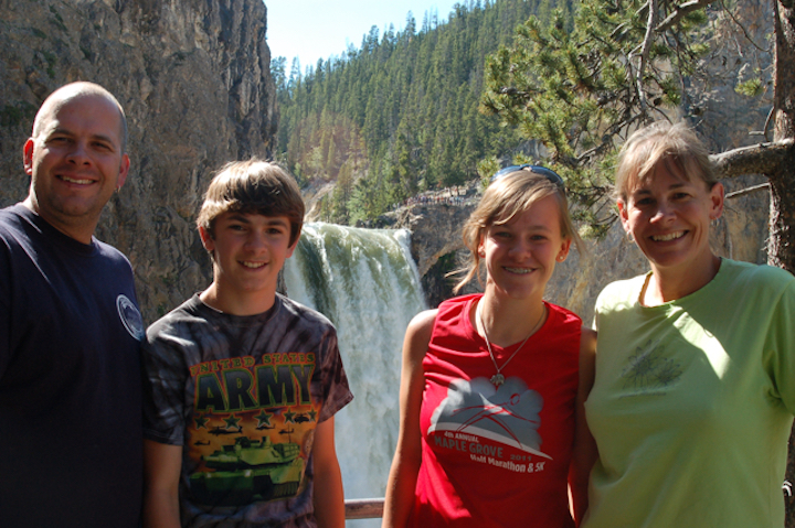 4 people standing in front of Yellowstone's lower falls