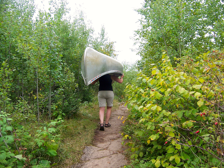 woman portaging a canoe