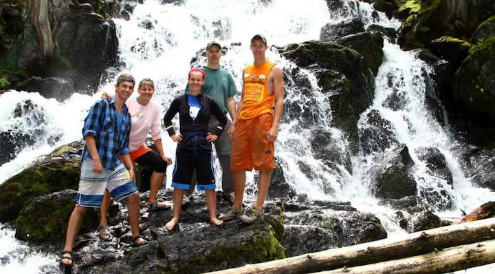 family of five standing at the bottom of a waterfall