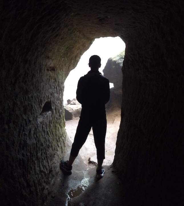 hiker inside a narrow tunnel along the trail