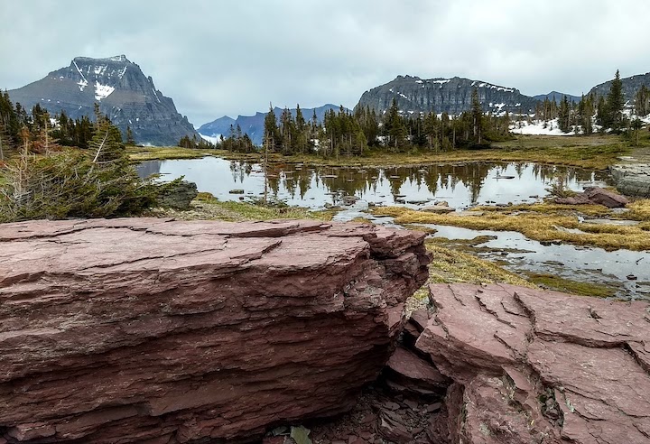 Purple rocks in the foreground of a mountain landscape