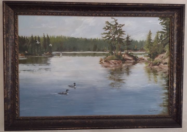 framed oil painting of loons on a northern lake