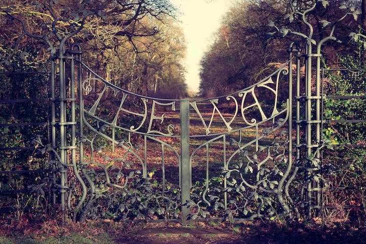 image of a gate with "The Way" sculped in the metal
