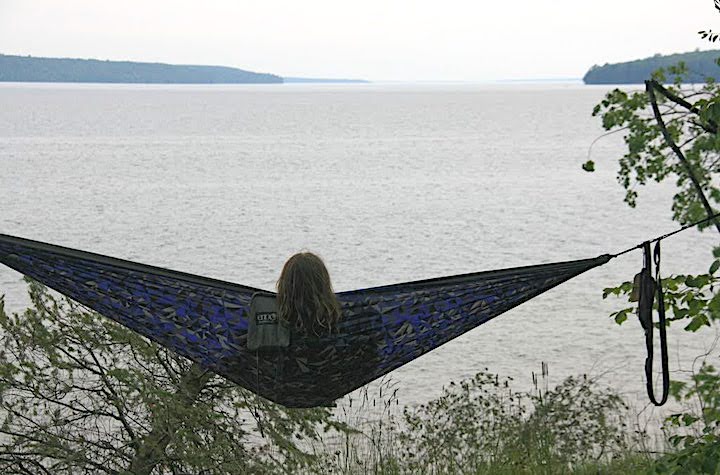 woman relaxes in a kayak overlooking a huge lake