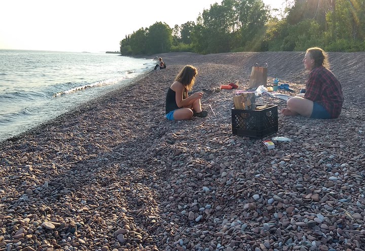 two women having a cookout at a beach