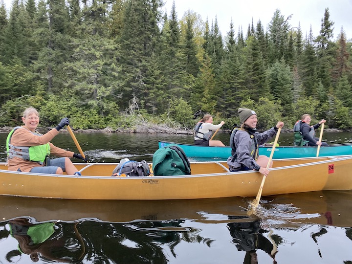 four women in two canoes on a canoe trip
