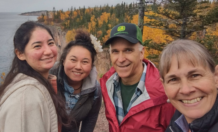 four smiling hikers in autumn