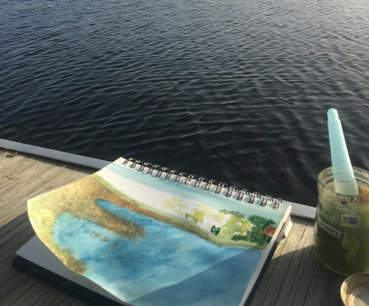 art journal on a dock next to a lake