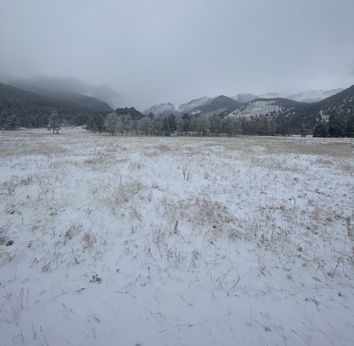 Colorado mountains across the meadow in snow and low clouds