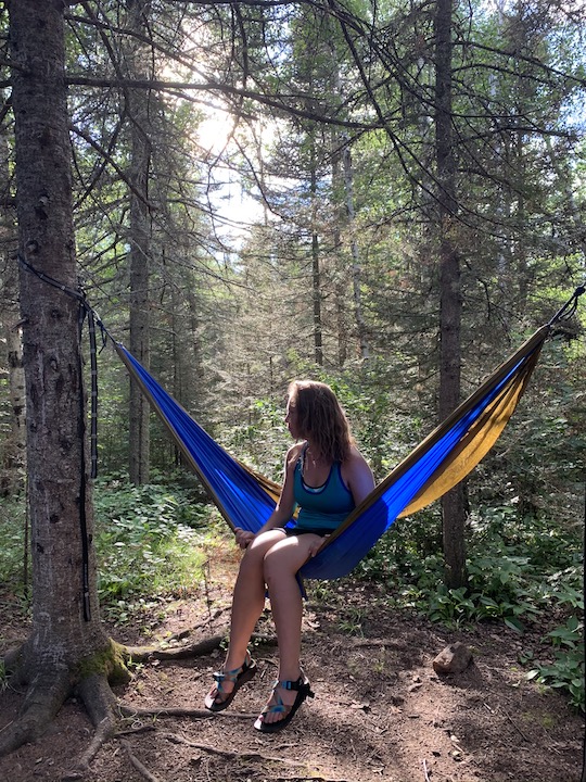 Author Emilie O'Connor sits in her hammock in the woods