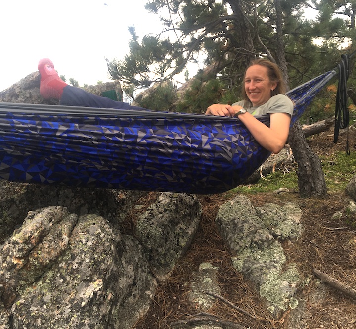 woman relaxes in her hammock with a big smile