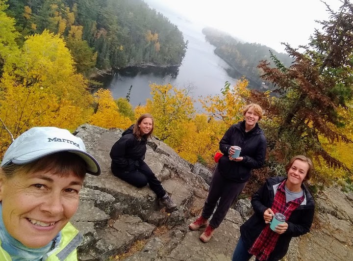 four women on a beautiful overlook with bright fall colors