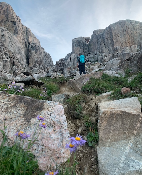 woman hiking up a mountain summit