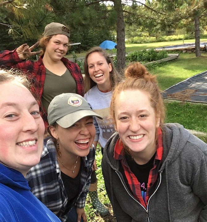 five young women smiling outdoors
