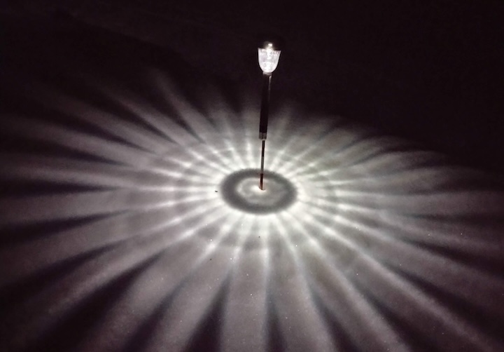 pattern of light from a solar light on the snow at night