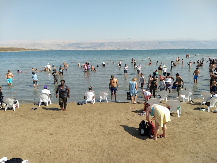 tourists wade and float in the Dead Sea in Israel